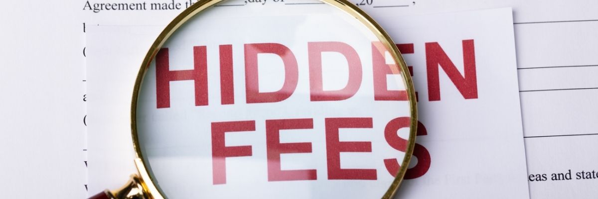 A magnifying lense over a document, with text saying hidden fees on it. This is to emphasizes the dangers of hidden fees people don't think about. 