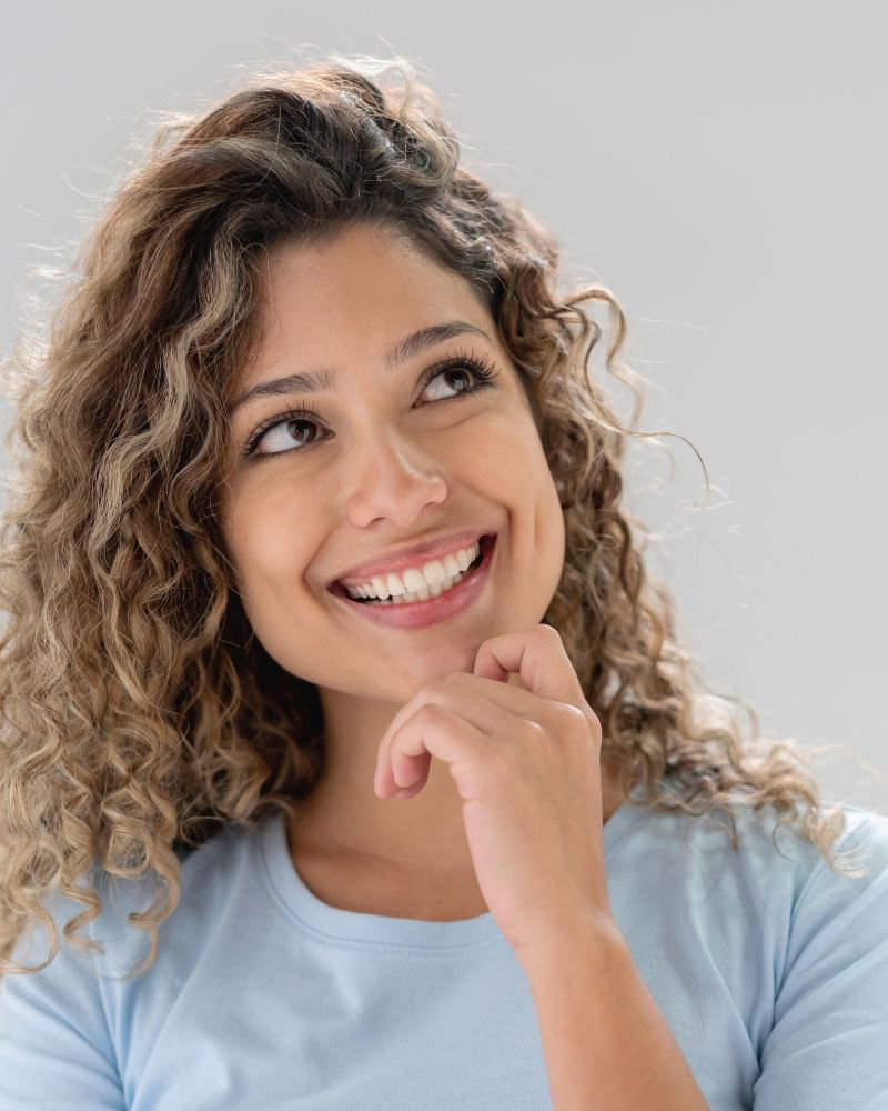 A woman choosing Smiles Club clear aligners over Alignerco and smiling.