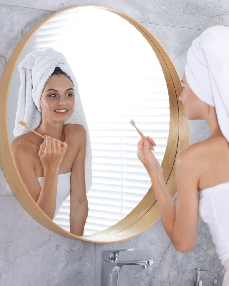 A woman choosing Smiles Club clear aligners in a mirror.