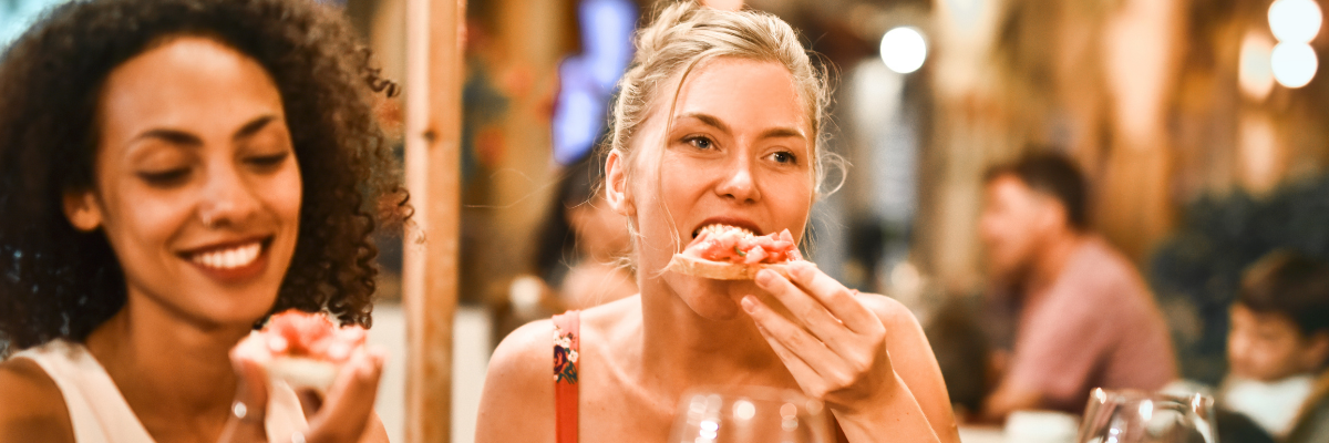 A woman eating with friends after having taken off her smiles club clear aligners.